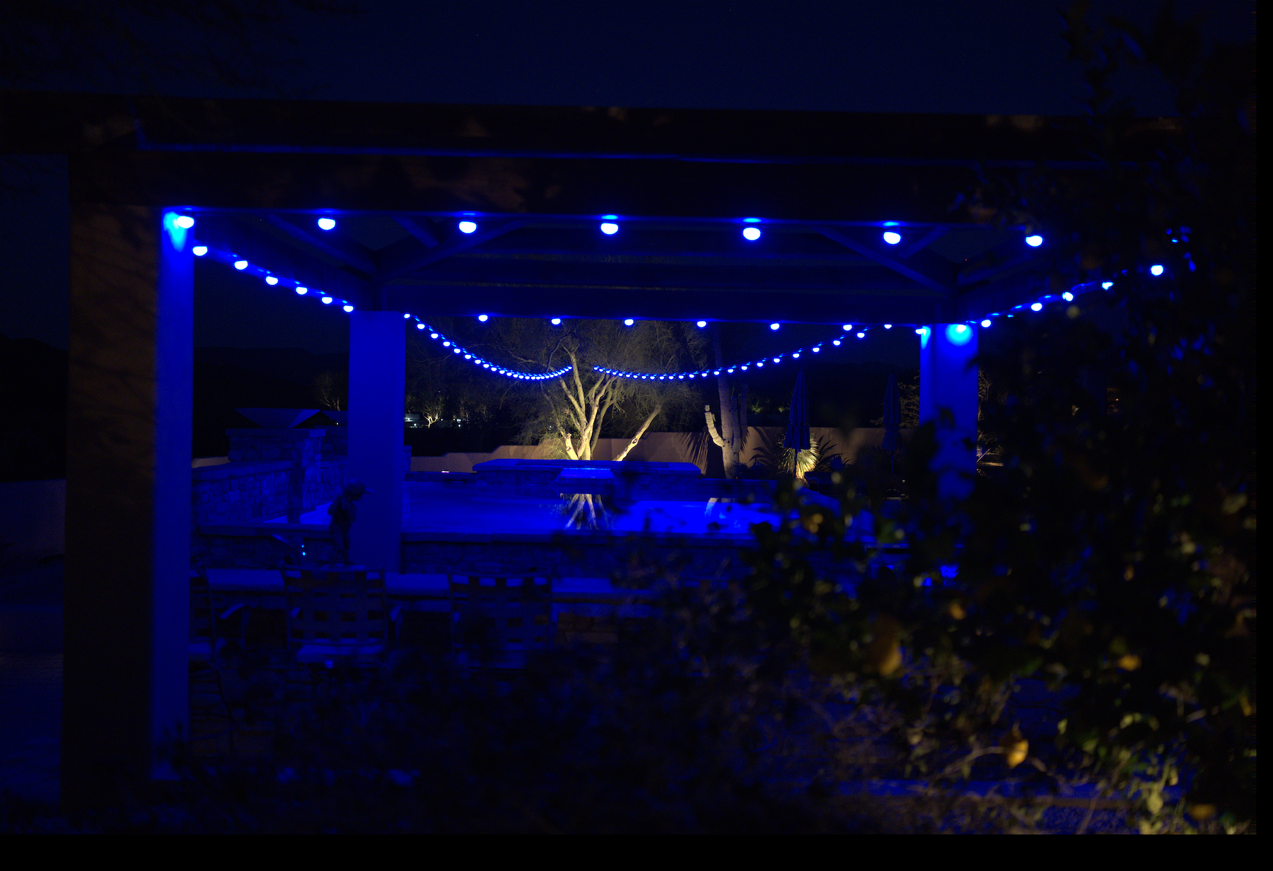 Gazebo with blue string lights in a dark outdoor setting